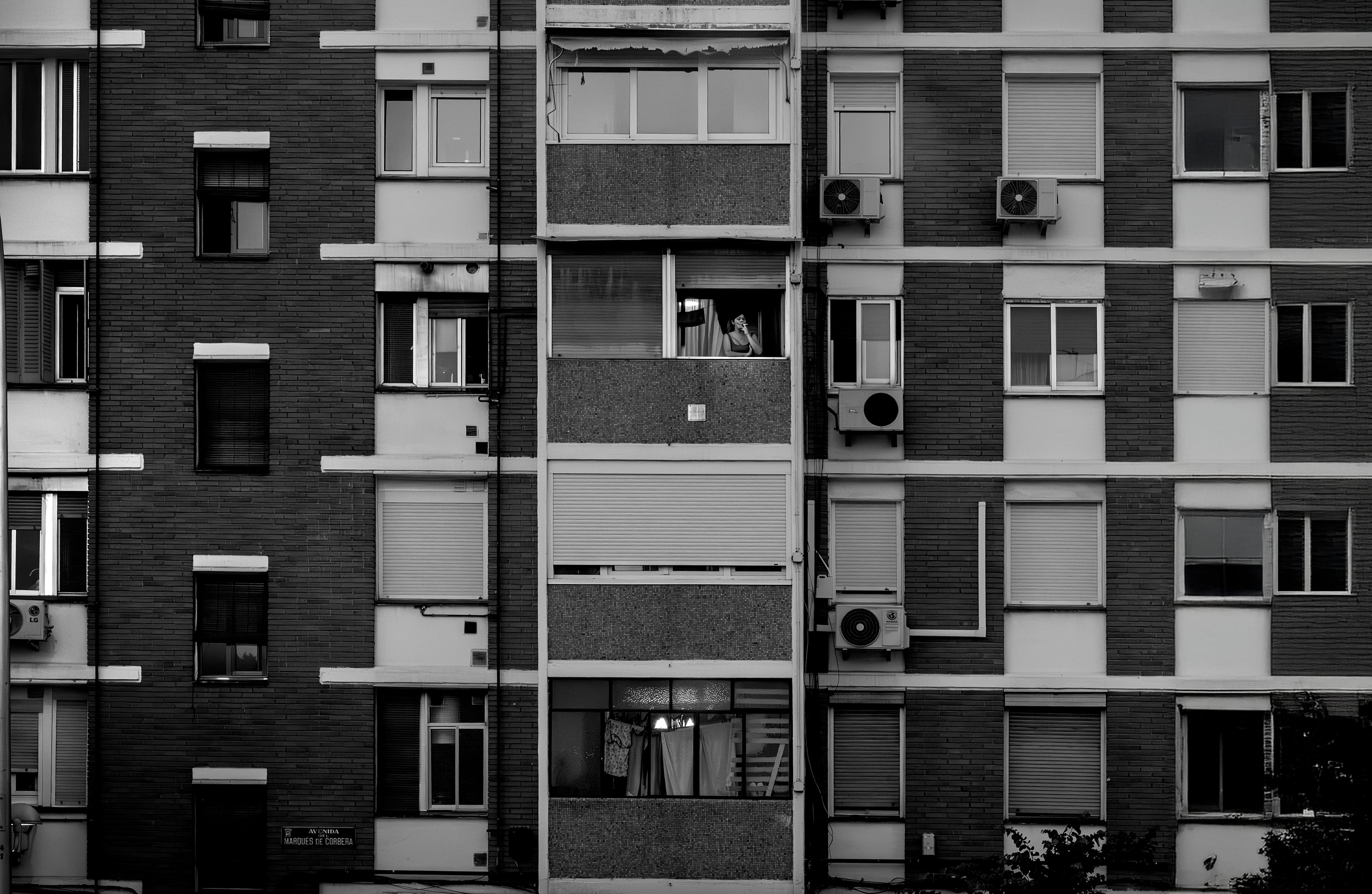 Una mujer en la ventana de un edificio en Madrid.