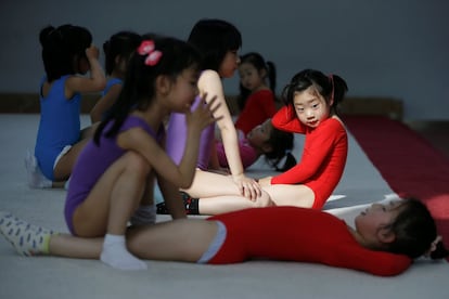 Un grupo de niñas practican abdominales durante las clases de gimnasia, en Shángai (China).