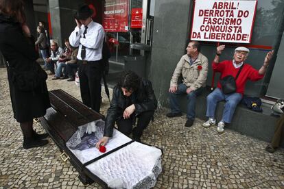 Un hombre coloca un clavel rojo en un ataud como símbolo del entierro de la libertad de Portugal a consecuencia de la situación económica