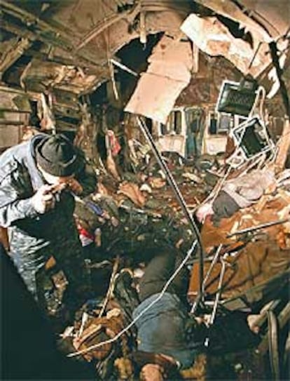 Un policía toma una fotografía de las víctimas del atentado entre los restos del vagón siniestrado.