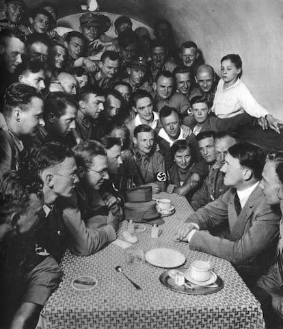 Adolf Hitler, rodeado por correligionários nazistas em uma mesa, em Berlim, em 1933.