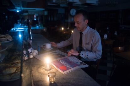 Un cliente lee el periódico dentro de un bar en Avenida de Mayo, durante el apagón más largo de la historia de Argentina hasta ese momento, e 16 de junio de 2019.