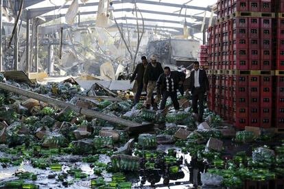 Varias personas inspeccionan la fábrica de Coca-Cola destruida en un ataque aéreo de la coalición liderada por Arabia Saudí en Saná (Yemen).