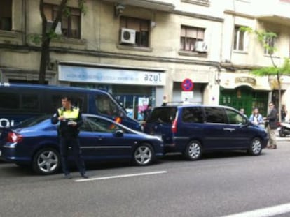 Agentes de la policía multan a los vehículos oficiales de los dirigentes socialistas aparcados en doble fila en la calle Ferraz.
