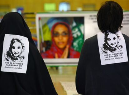 Dos personas, con leyendas en su espalda, protestan en el aeropuerto de Lanzarote por la situación de la activista saharaui Aminetu Haidar.