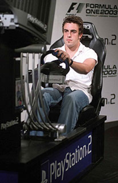 El joven piloto español Fernando Alonso, al volante de un simulador, jugando al <b><i>Formula One 2003.</b></i>