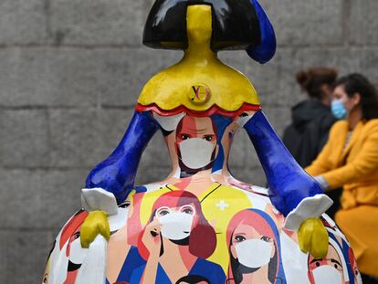 Varias personas pasan junto a una 'menina', decorada con sanitarios con mascarilla, este viernes en Madrid.