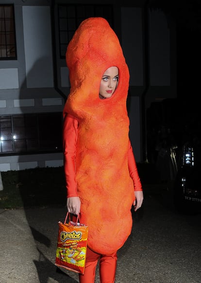 El disfraz de Cheeto en la fiesta de Halloween de Kate Hudson. En 2014, Perry decidió convertirse en un 'cheeto' de la línea Flaming Hot gigante; un divertido y original atuendo que acompañó con una bolsa de la misma marca a modo de bolso para acudir a la fiesta de Halloween de la actriz Kate Hudson en Los Ángeles. La cantante optó por dejar atrás su imagen de símbolo sexual para convertirse en un aperitivo picante. Este disfraz llamó la atención de los medios no solo por su originalidad sino por lo que representaba para la famosa. “Hubo dos semanas en mi vida, después de saber la verdad sobre mi matrimonio [con Rusell Brand], donde solo estuve comiendo 'Cheetos Flamin’ Hot' y bebiendo. Nada más”, reveló Perry a 'Marie Claire' en 2011. Quizá haya sido su disfraz más inesperado, pero tampoco se quedan atrás los momentos en los que se puso en la piel de Úrsula, la mala de 'La sirenita'; Daenerys Targaryen, con su perro como el dragón Drogon; o de una simple hamburguesa con queso para la fiesta de la gala del Met de 2019.