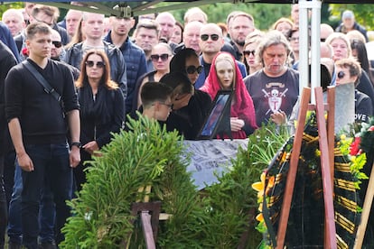 People react by the coffin of the Wagner Group's logistics chief Valery Chekalov, killed in the plane crash, during a funeral at the Severnoye cemetery in St. Petersburg, Russia, Tuesday, Aug. 29, 2023.