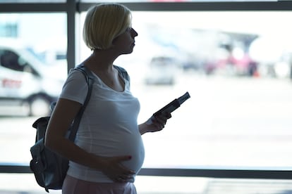 Una mujer embarazada en un aeropuerto.