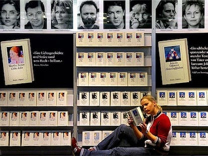 Una joven lee delante de uno de los expositores de la Feria del Libro de Fráncfort.