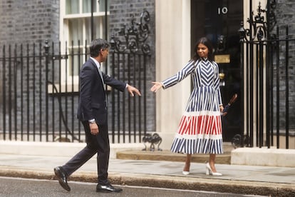 Rishi Sunak coge la mano de su mujer, Akshata Murty, al termino de la rueda de prensa en Downing Street, este viernes. 