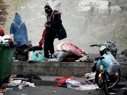 Migrantes recogen sus pertenencias durante la evacuación de dos campamentos en París
