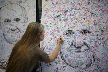 Una joven que asiste al Encuentro Mundial de las Familias firma un dibujo de Francisco, obra del artista Marcos Gaines, en Filadelfia, Pennsylvania (EE UU).