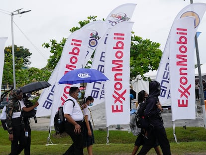 High school students walk past ExxonMobil flags as they arrive to a job fair at the University of Guyana in Georgetown, Guyana, April 21, 2023.