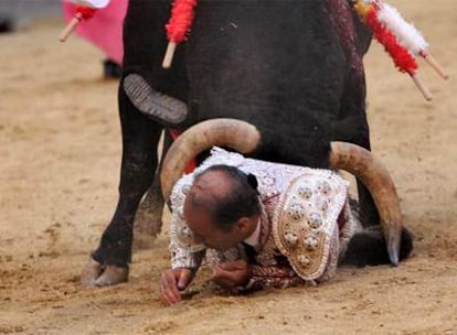 Domingo Vicente, banderillero del maestro Matías Tejela, entre los pitones del sexto toro de la tarde, ayer en Las Ventas.