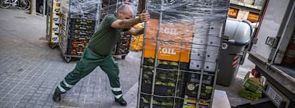 Un trabajador abastece un supermercado en Barcelona durante los primeros días del estado de alarma por el coronavirus.