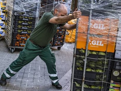 Un trabajador abastece un supermercado en Barcelona durante los primeros días del estado de alarma por el coronavirus. 