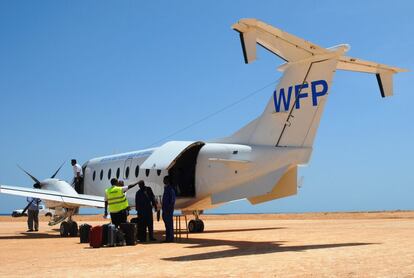 El personal y la tripulación del Servicio Aéreo Humanitario de Naciones Unidas (UNHAS), gestionado por WFP, cargan maletas antes del despegue en el aeródromo de la policía marítima de Bosaso, Puntlandia, en la provincia de Bari. Bosaso es uno de los 13 destinos regulares en los que trabaja UNHAS en Somalia.