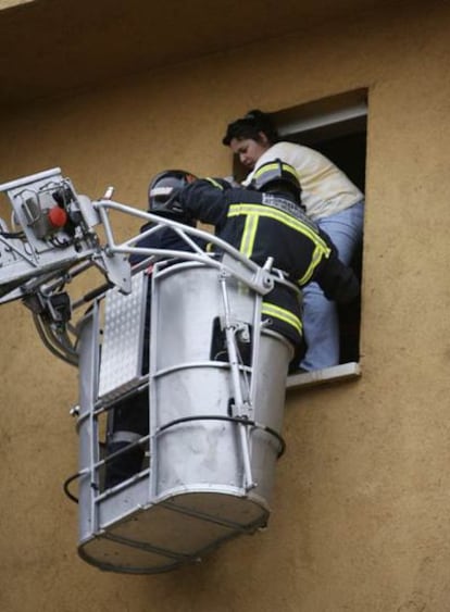 Dos bomberos rescatan a una vecina de la vivienda incendiada en Guadalajara