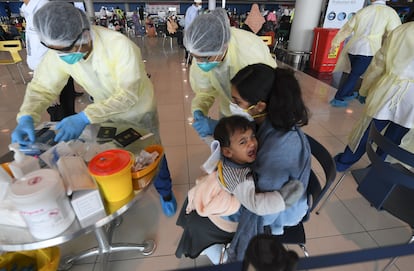 Unos sanitarios toman muestras de sangre de un bebé indio, este jueves en el aeropuerto de Dubái.