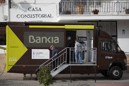 Varios ciudadanos hacen uso de un camión-oficina bancaria en Corpa (Madrid), en 2018.