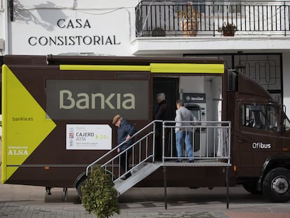 Varios ciudadanos hacen uso de un camión-oficina bancaria en Corpa (Madrid), en 2018.
