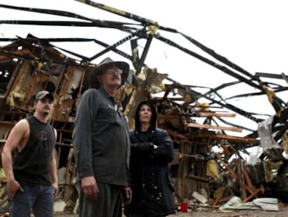 Los dueños de un negocio en el sur de Indiana, tras el paso de un tornado.