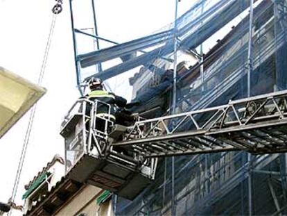 Los bomberos rescatan a los dos obreros que quedaron atrapados tras venirse abajo el andamio en el que trabajaban, en el distrito de Centro.