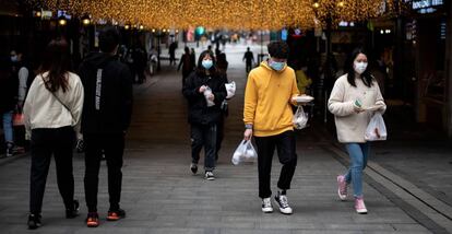 Varias personas en una calle comercial en Wuhan (China).