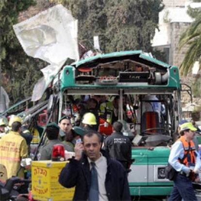 La policía y los servicios de rescate examinan el autobús objeto del atentado.
