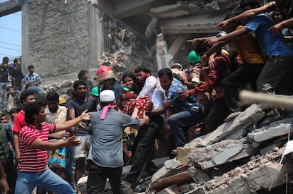 Voluntarios rescatan a una joven del edificio de ocho plantas que se ha derrumbado en Dacca (Bangladesh).