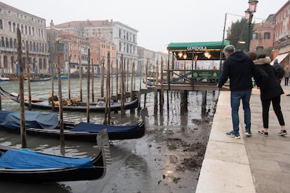 Turistas observando las góndolas varadas en la orilla de uno de los canales principales, este martes en Venencia.
