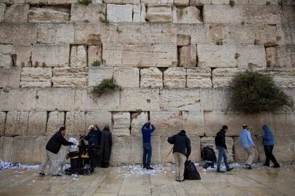 Empleados retiran las notas colocadas por los creyentes en el Muro de Las Lamentaciones antes de la celebración de la Pascua en Jerusalén.