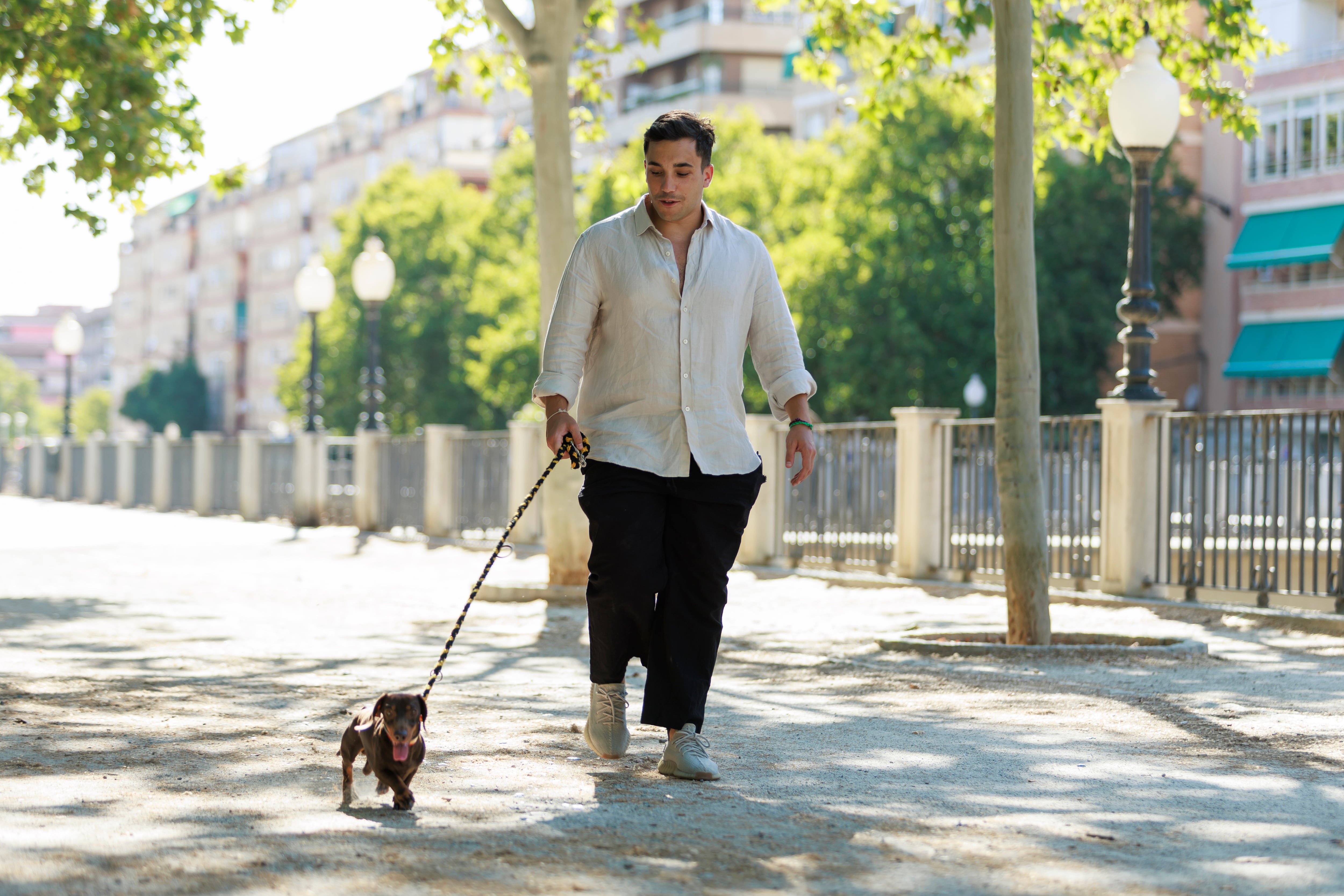 Manuel Piñar Ibáñez, de 29 años, camina en las calles de Granada junto a su perro salchicha, Rufo.