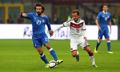 Pirlo y Goetze pugnan un balón en el partido disputado en Milán.