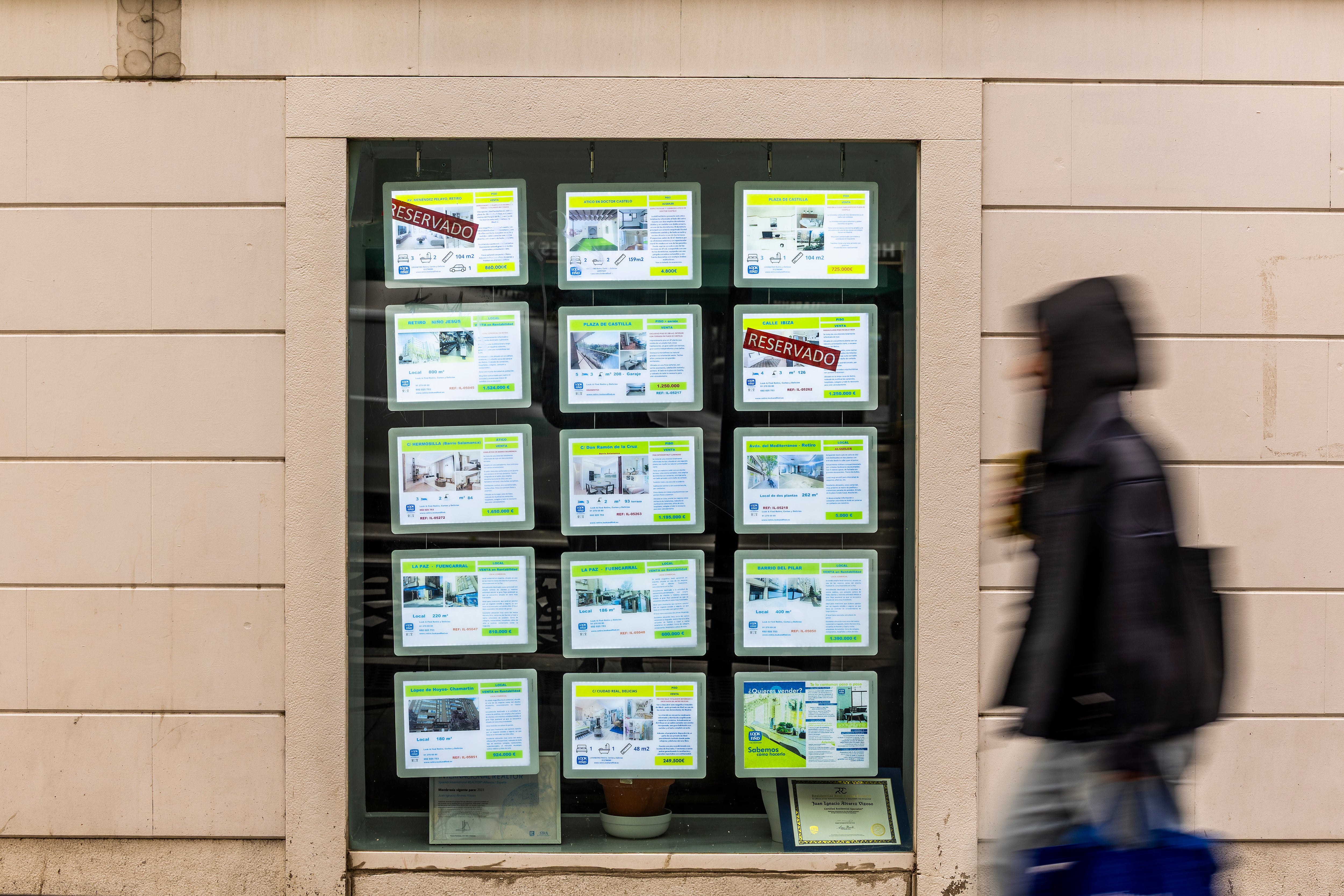 Una persona pasa por delante de una inmobiliaria en la calle Narváez (Madrid).