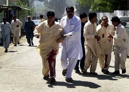 Varios hombres heridos reciben ayuda tras el atentado suicida en la reunión del partido nacionalista pastún Awami en Timergarah, en la Provincia de la Frontera del Noroeste, en Pakistán.