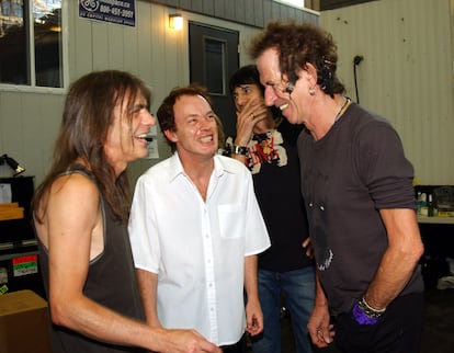 Malcolm and Angus Young talking to Keith Richards backstage at a concert in Toronto (Canada), in 2003. Behind, also 'stone' Ronnie Wood.