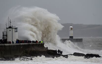 Un grupo de personas observa el estado del mar en el faro de Porthcawl, en el sur del Reino Unido. La tormenta Dennis ha provocado olas gigantescas en esta zona.
