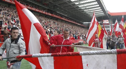 Aficionados del Sporting de Gijón ondean banderas de su equipo en El Molinón durante la misa en recuerdo del que fuera su entrenador, Manuel Preciado