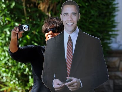 Una partidaria de Obama toma fotos, tras una figura de cartón del presidente. 
