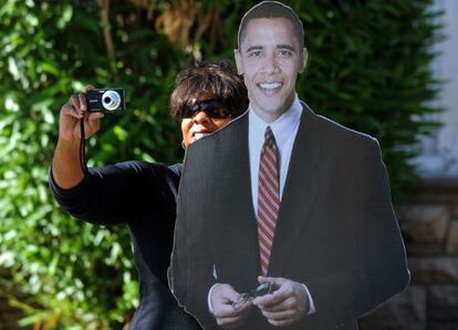 Una partidaria de Obama toma fotos, tras una figura de cartón del presidente.