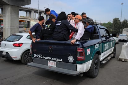 Usuarios del metro férreo, cuyo servicio fue parcialmente suspendido, son transportado en un vehículo de la Policía Auxiliar de Ciudad de México. 