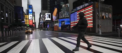 Un hombre cruza Times Square, en Nueva York, donde el alcalde ha pedido a los ciudadanos que se queden en casa para evitar la propagación del coronavirus.