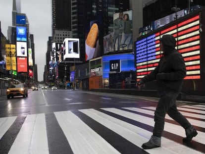 Un hombre cruza Times Square, en Nueva York, donde el alcalde ha pedido a los ciudadanos que se queden en casa para evitar la propagación del coronavirus.