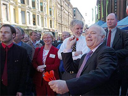 El ministro de Exteriores español, Miguel Ángel Moratinos, juega a los dardos en el centro de seguimiento de las elecciones europeas, el jueves en Helsinki.