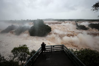 Un hombre mira las Cataratas del Iguazú con el alto nivel del agua que en los últimos días ha aumentado debido a las fuertes lluvias que azotaron la región sur de Brasil, en Foz do Iguacu, Estado de Paraná.
