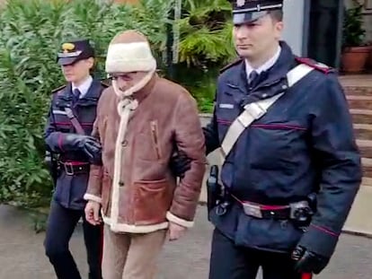 In this picture taken from a video released by Italian Carabinieri on Monday, Jan. 16, 2023, top Mafia boss Matteo Messina Denaro, center, leaves an Italian Carabinieri barrack soon after his arrest at a private clinic in Palermo, Sicily, after 30 years on the run, Monday, Jan. 16, 2023. (Carabinieri via AP)