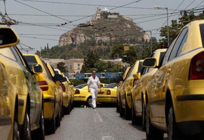Un taxista camina entre los coches que bloquean los accesos al aeropuerto internacional de Atenas